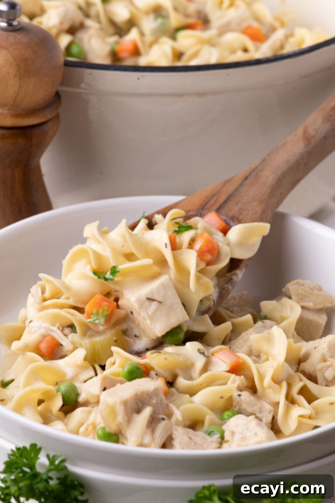 Hearty Chicken Pot Pie Pasta 2 Chicken Pot Pie Pasta being spooned into a bowl, showcasing the creamy sauce, noodles, chicken, and vegetables