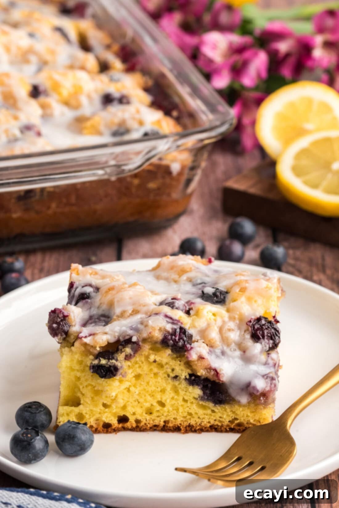 Tender Blueberry Cake with Zesty Lemon Glaze 3 Slice of Glazed Lemon Blueberry Cake on a plate
