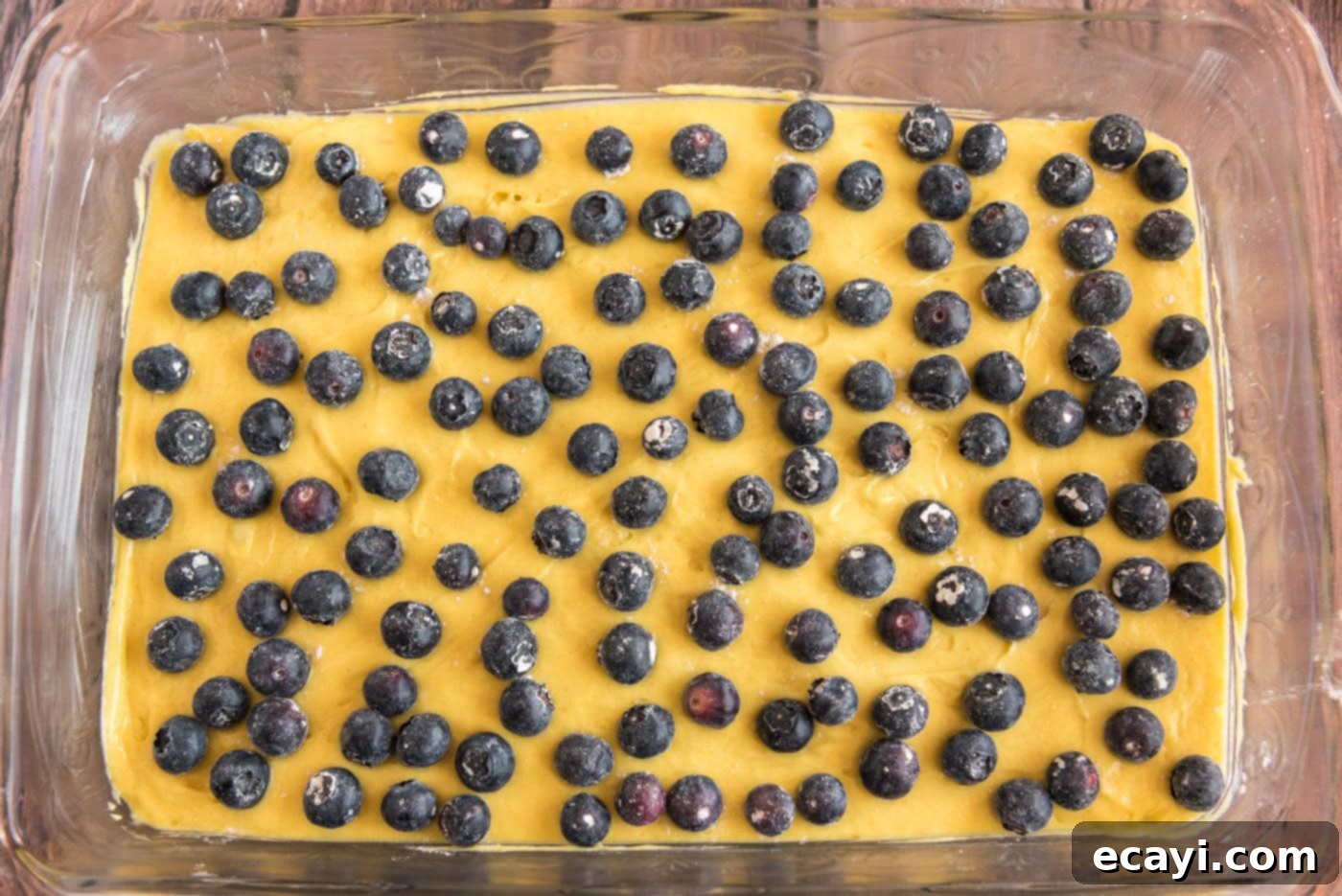 Tender Blueberry Cake with Zesty Lemon Glaze 7 blueberries on top of lemon cake batter