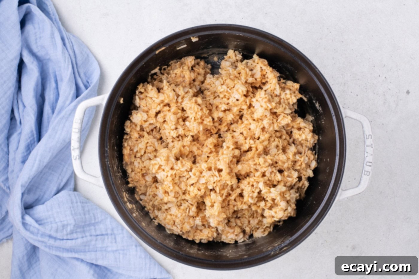 Crunchy Peanut Butter Krispie Delights 8 Rice Krispies cereal being folded into the warm peanut butter and marshmallow mixture in a pot.