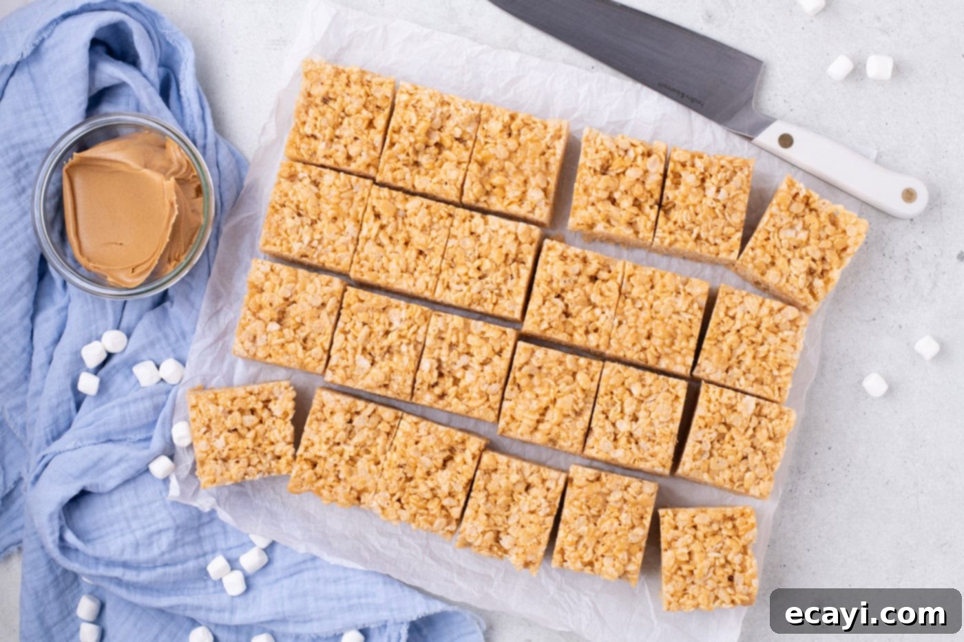 Crunchy Peanut Butter Krispie Delights 10 Sliced peanut butter Rice Krispie treats arranged neatly on parchment paper, ready to be enjoyed.