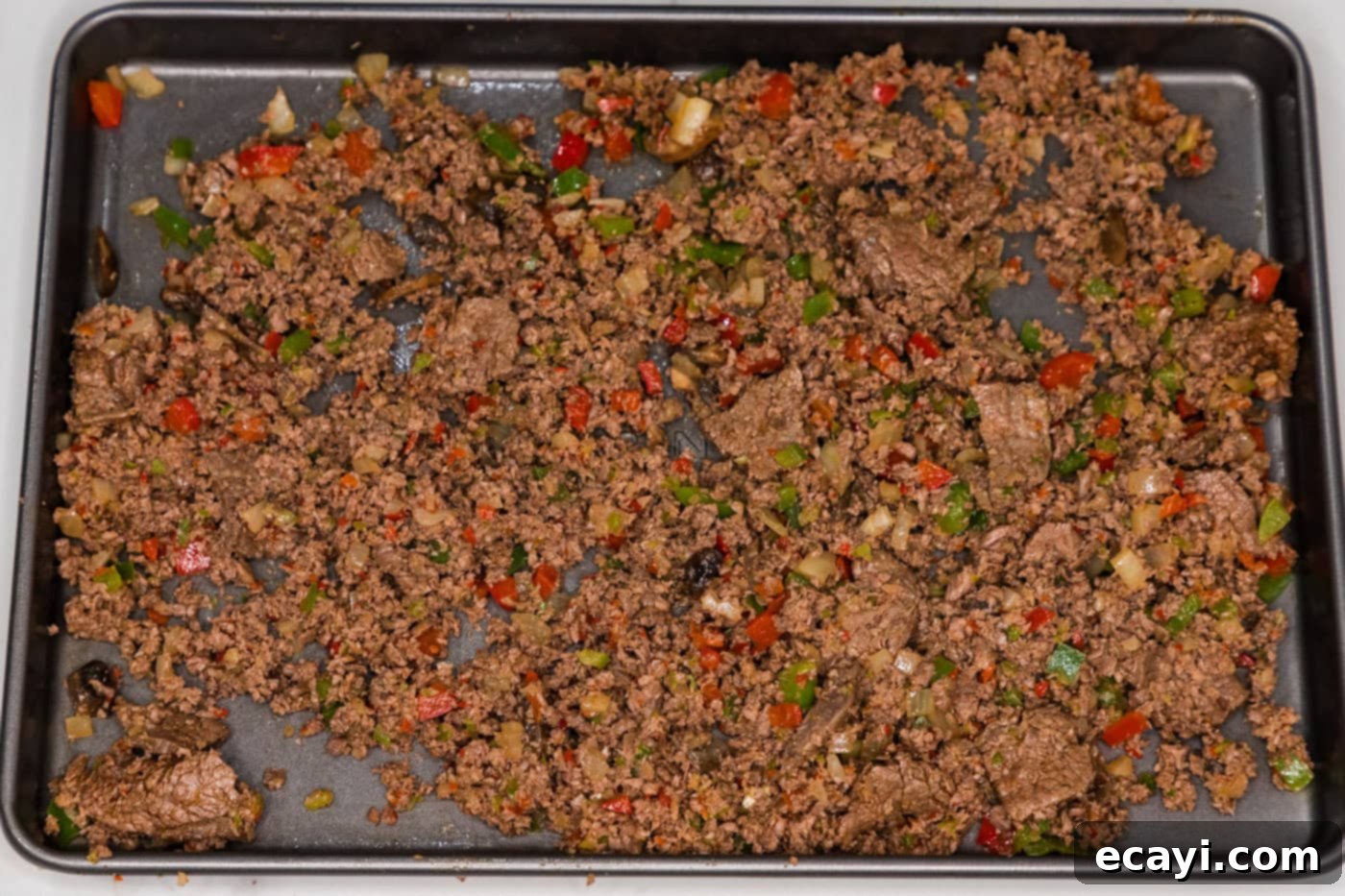 Crispy Philly Cheesesteak Rolls 9 meat mixture on a baking sheet