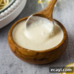 Zesty Lemon Cream 9 Bowl of Lemon Cream Sauce with a spoon in it, ready to be served.