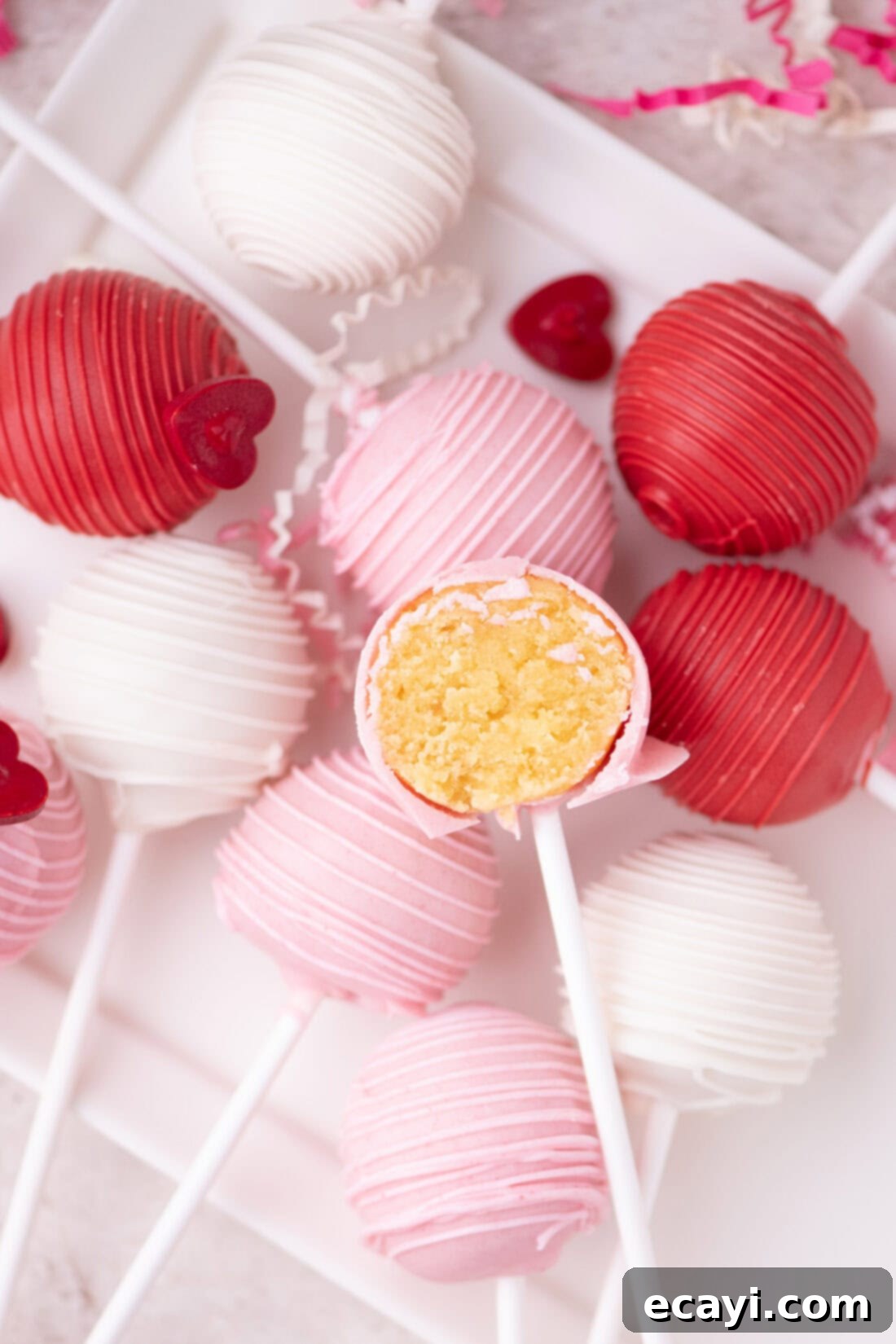 Sweetheart Cake Pops 3 Assortment of Valentine Cake Pops resting on a plate, with one thoughtfully cut in half to reveal its moist cake interior