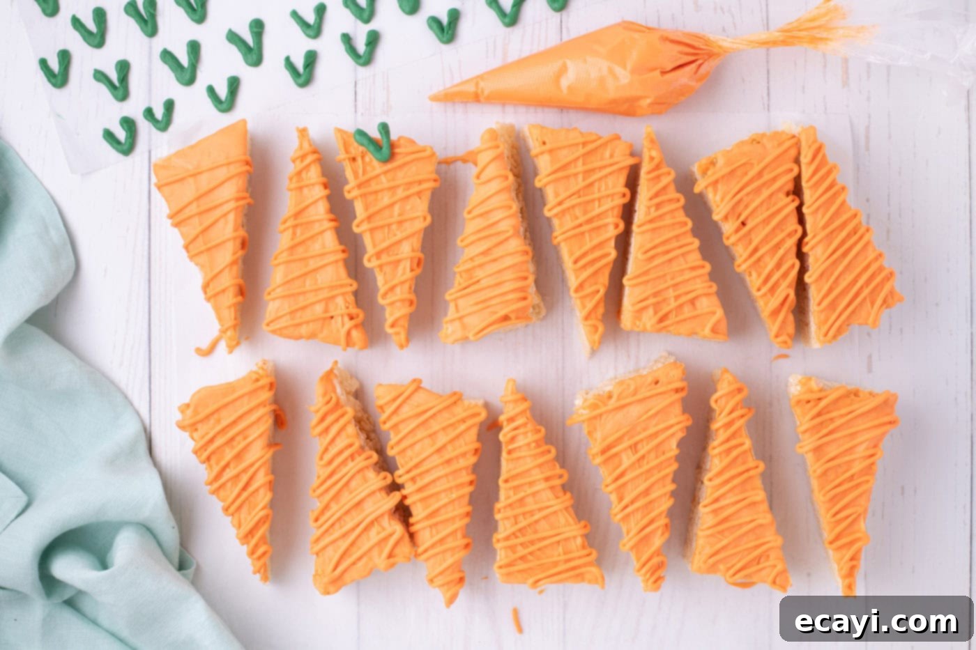 Carrot Cake Krispie Squares 12 Close-up of fully decorated carrot Rice Krispie treats, dipped and drizzled with orange chocolate and topped with green candy stems