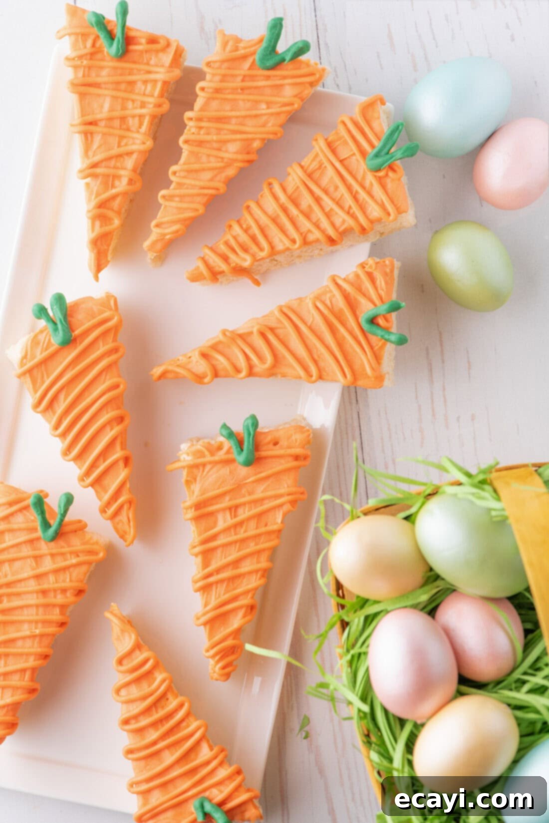 Carrot Cake Krispie Squares 13 Carrot Rice Krispie Treats beautifully arranged on a white platter with decorative Easter eggs