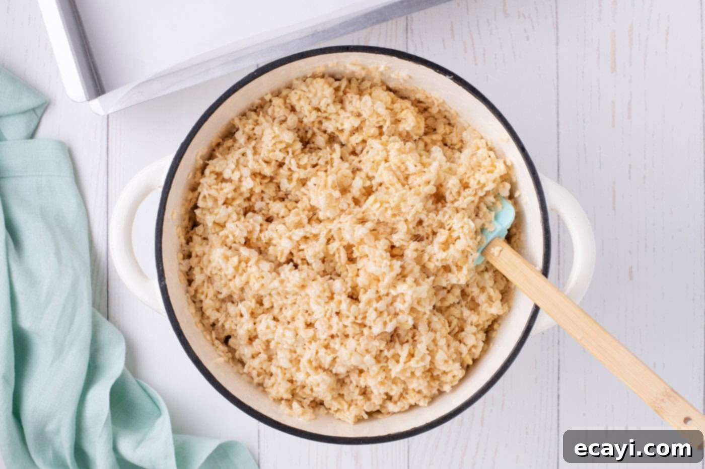 Carrot Cake Krispie Squares 7 Mixing Rice Krispies cereal into melted marshmallows in a pot with a spatula