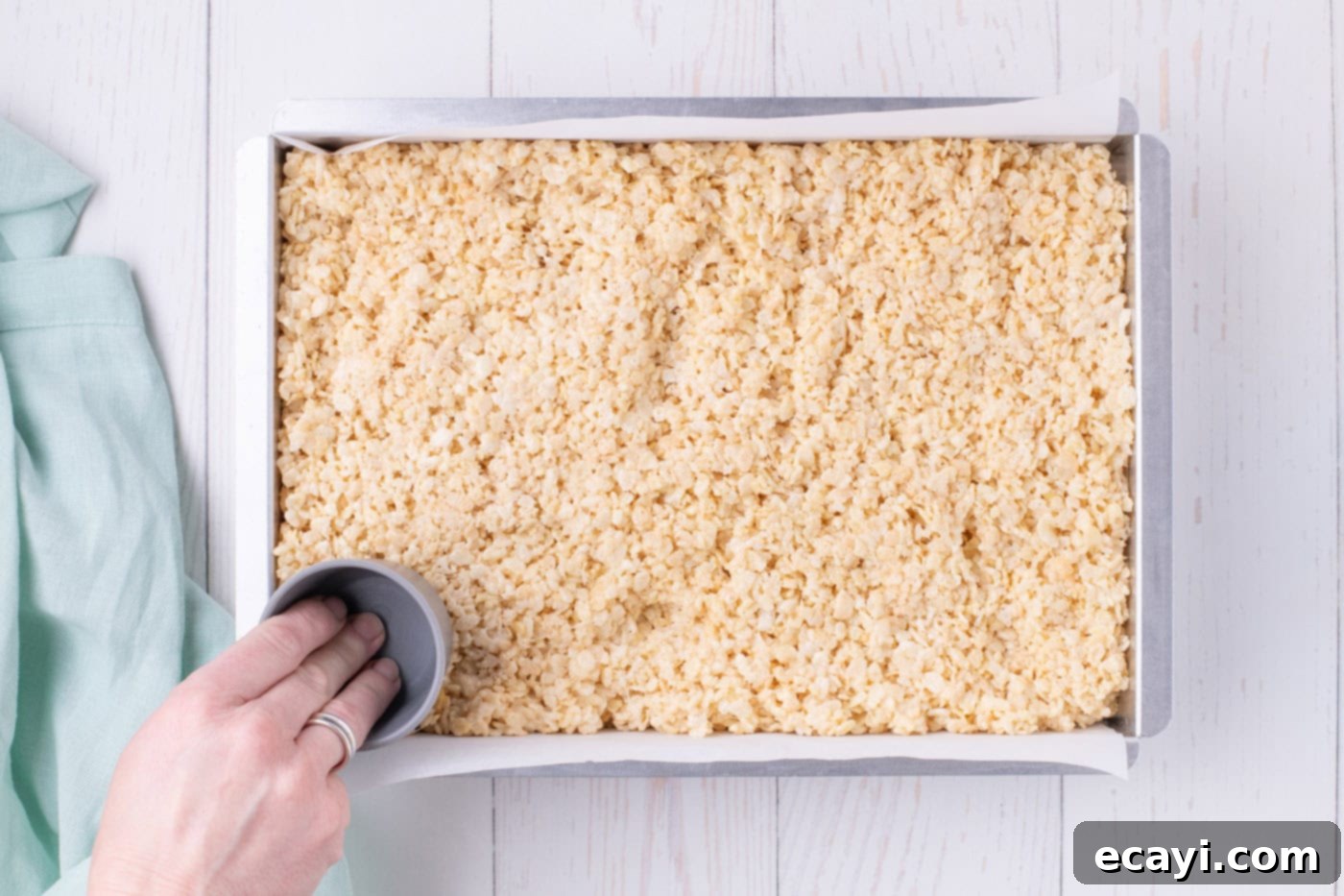 Carrot Cake Krispie Squares 8 Pressing Rice Krispie treats mixture firmly into a baking dish with a measuring cup to compact it