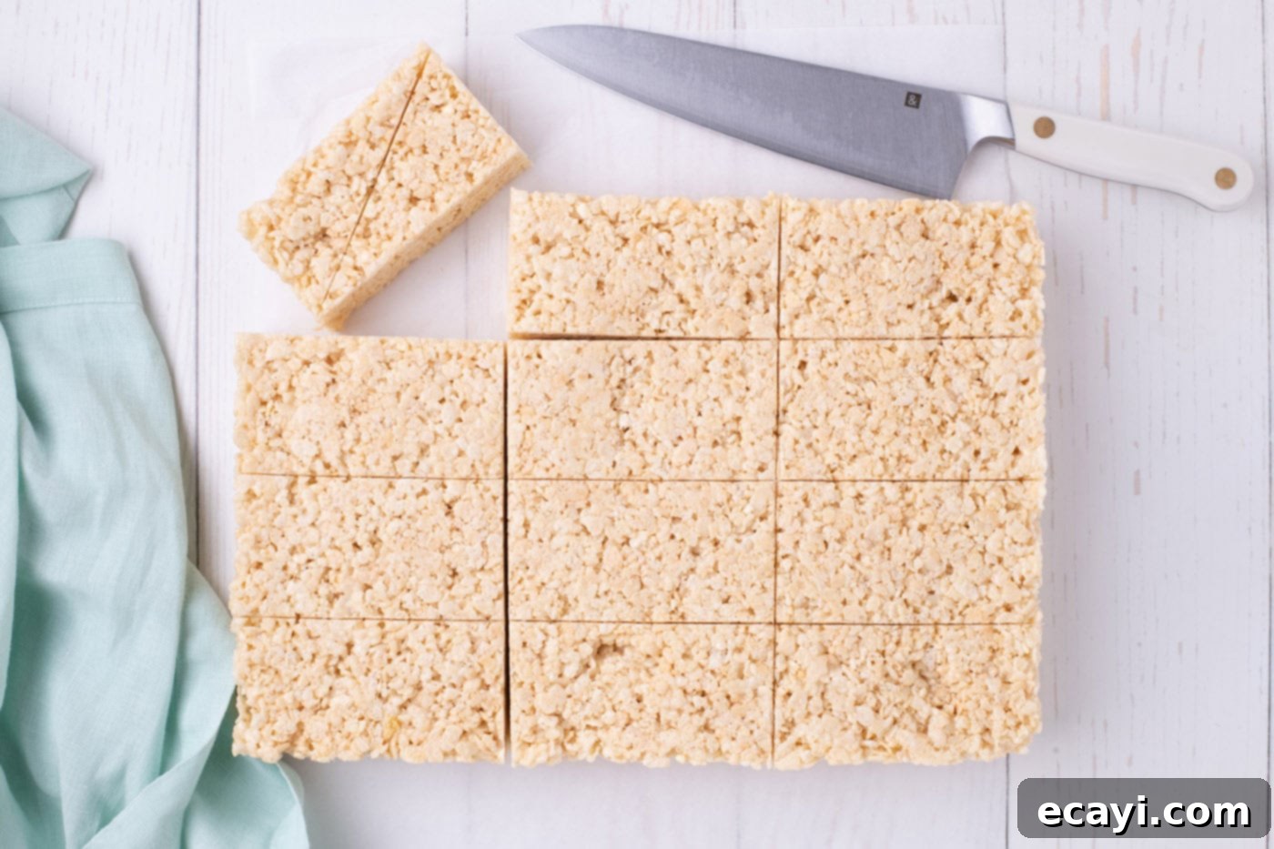 Carrot Cake Krispie Squares 9 Precisely sliced Rice Krispie treats in uniform rectangles on a cutting board, ready for diagonal cuts