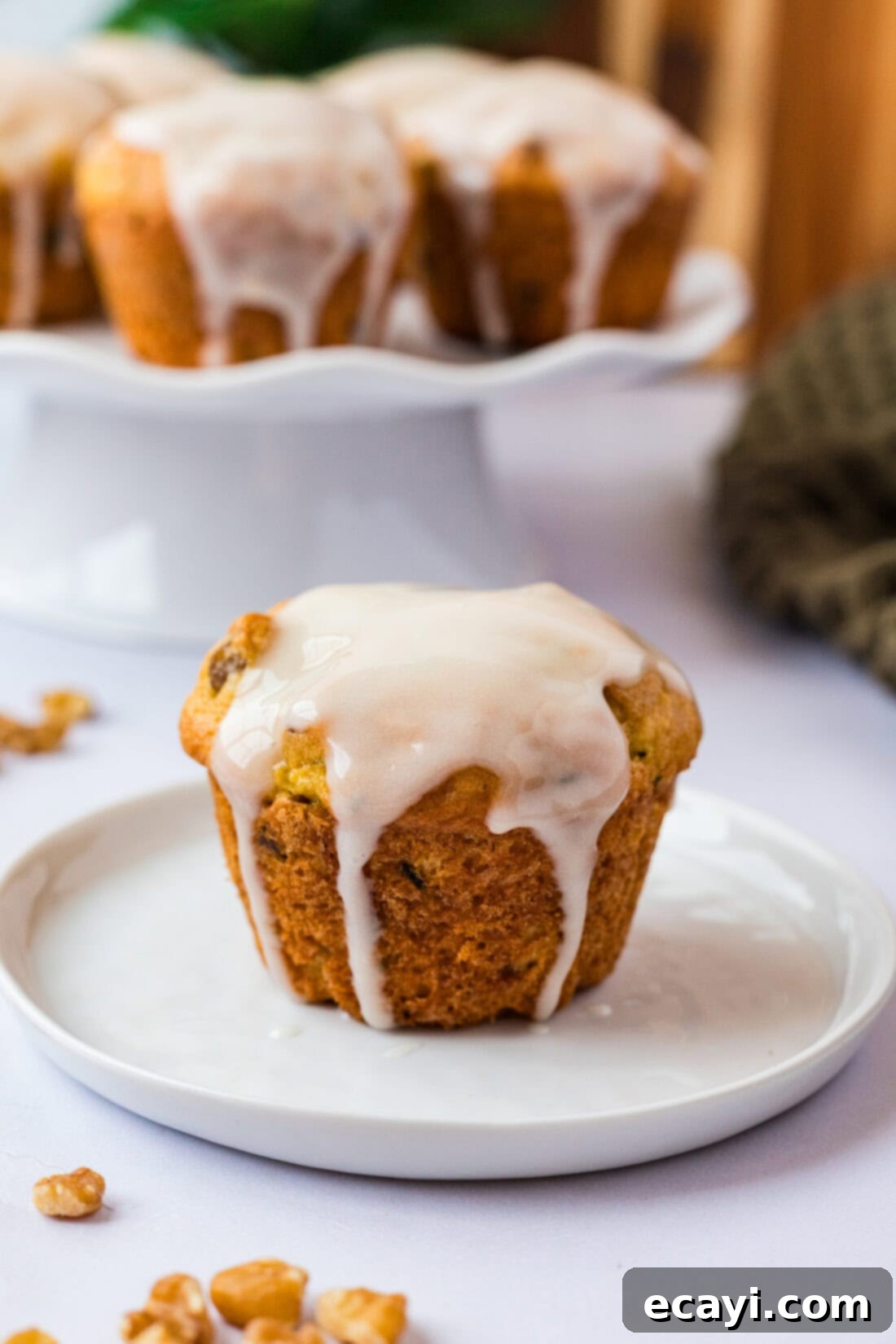 Quick Zucchini Muffins 3 Shortcut Zucchini Muffins on a white plate with more muffins behind it