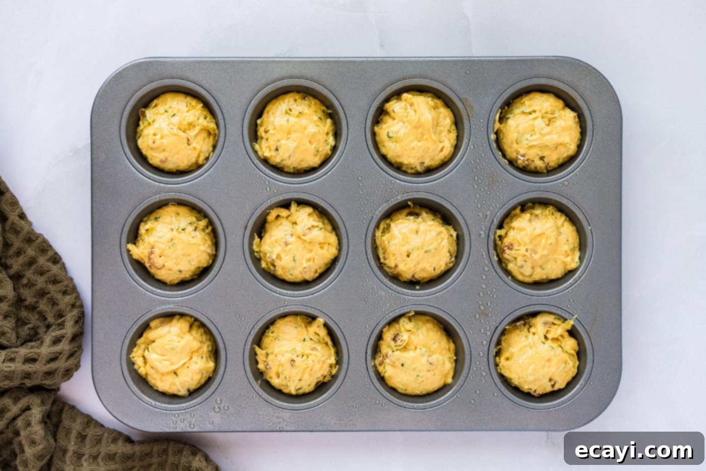 Quick Zucchini Muffins 7 muffin pan filled with zucchini muffin batter