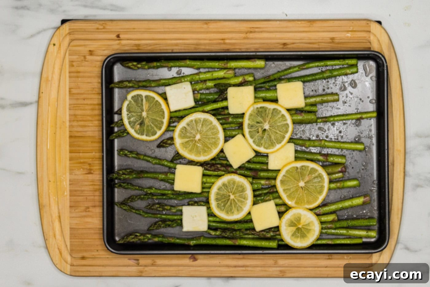 Bright Lemon Asparagus 7 asparagus on a pan with butter pats and lemon slices
