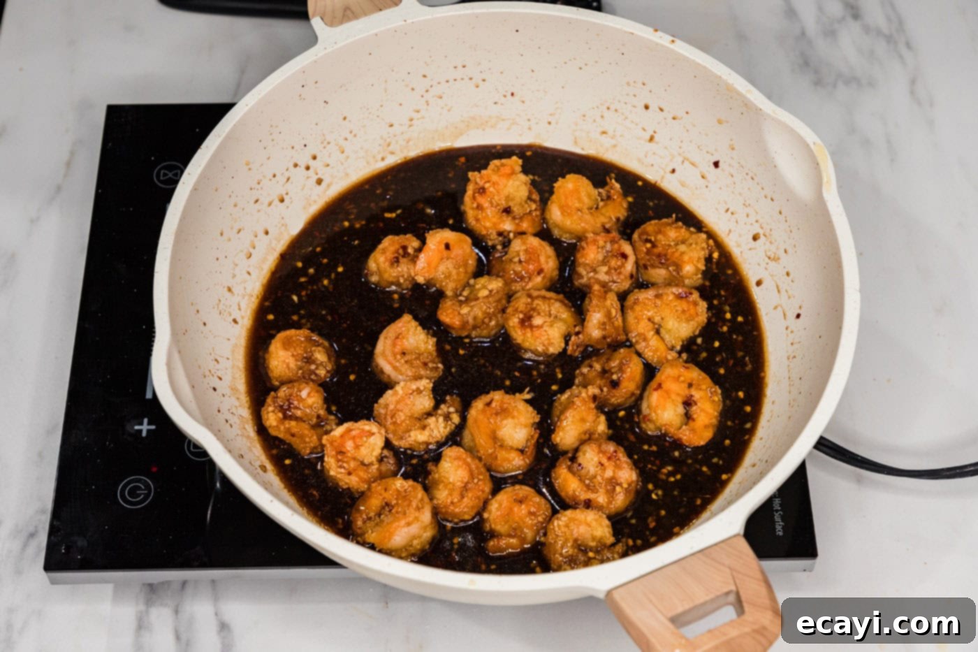 Glazed Mongolian Shrimp 12 breaded shrimp in a skillet with mongolian sauce