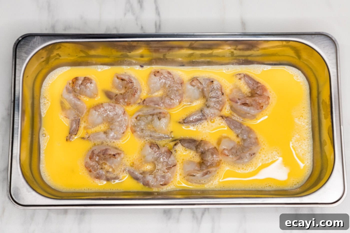 Glazed Mongolian Shrimp 5 shrimp in a breading tray with egg