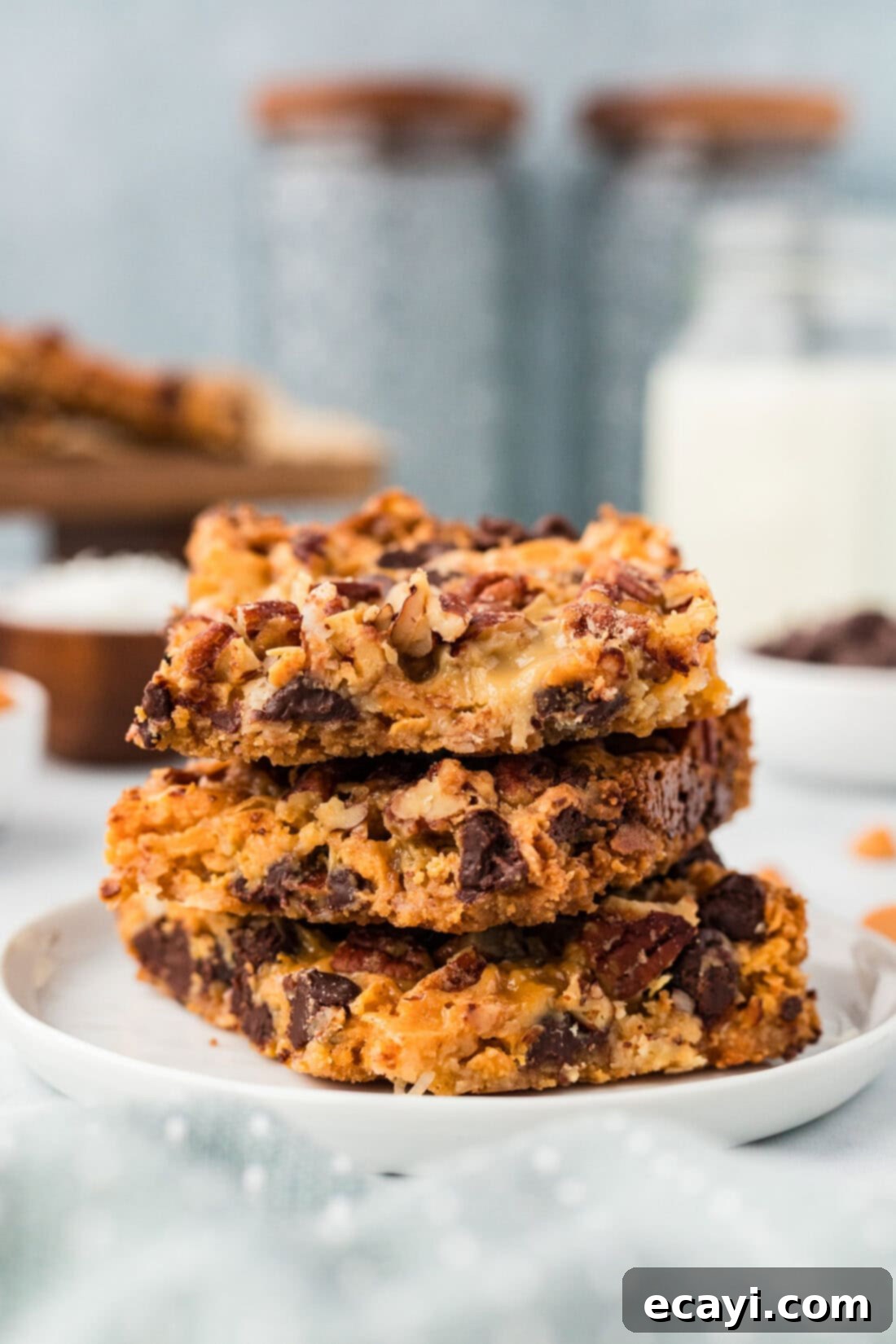 Pure Magic Dessert Bars 3 A stack of golden-brown Magic Bars on a white plate, showcasing their layers.
