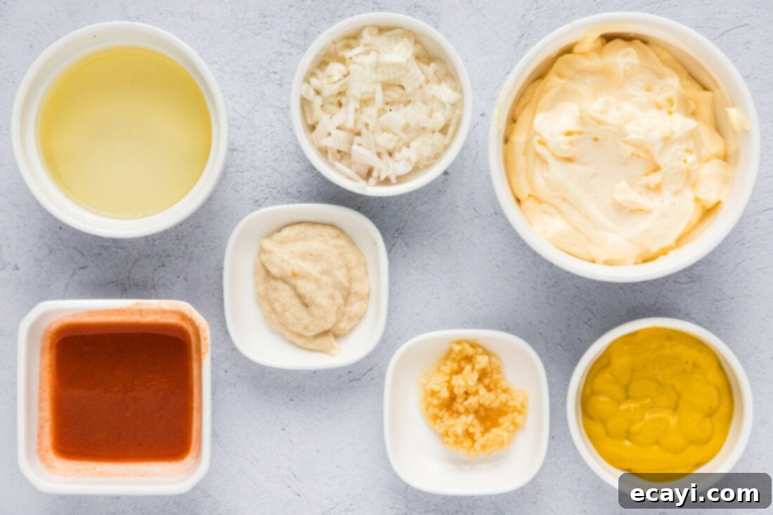 Classic Remoulade 4 Various fresh ingredients laid out on a kitchen counter, including mayonnaise, mustard, shallots, garlic, lemon, and hot sauce, ready for making remoulade.