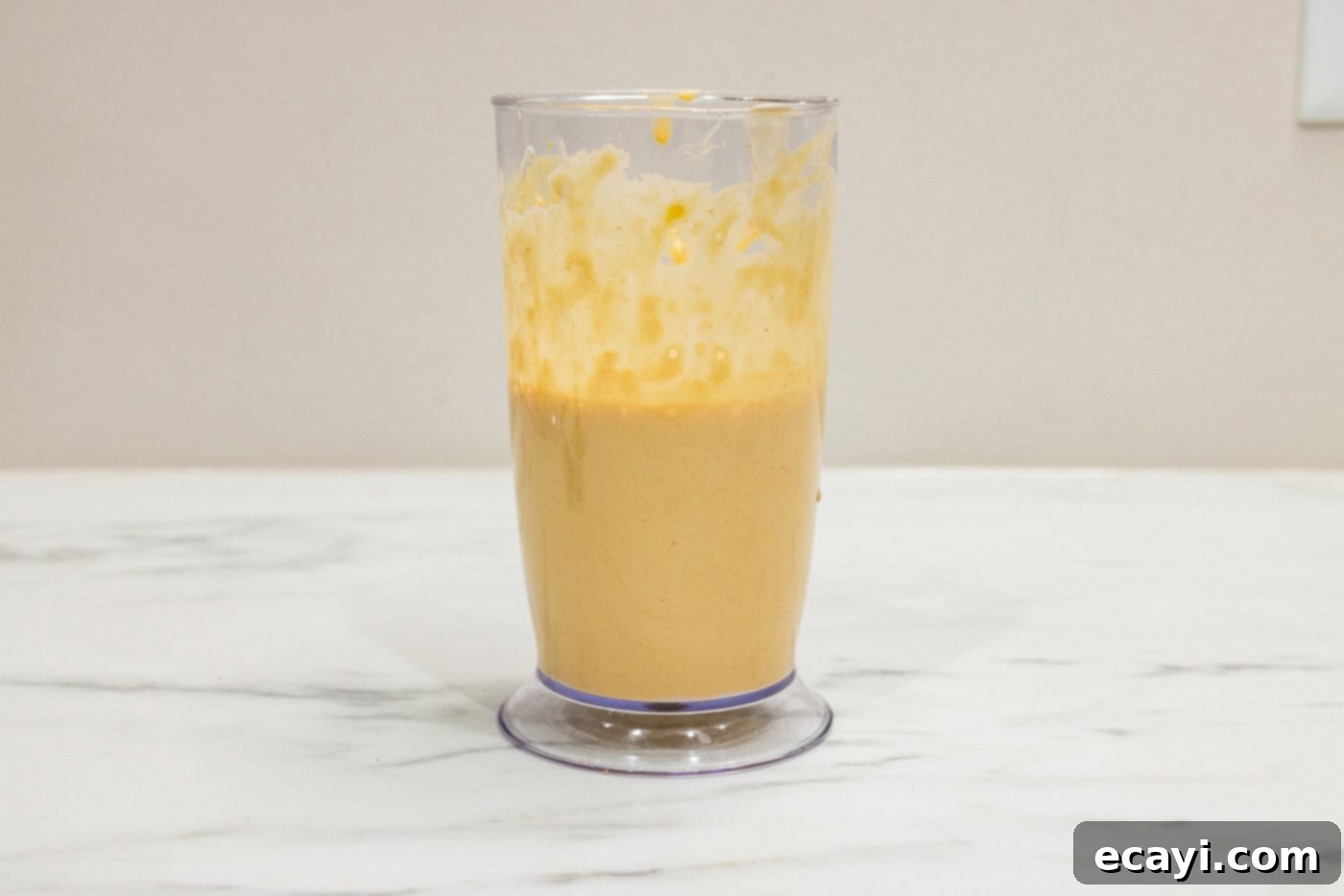 Classic Remoulade 6 An immersion blender actively mixing remoulade sauce ingredients in a container until smooth and creamy.