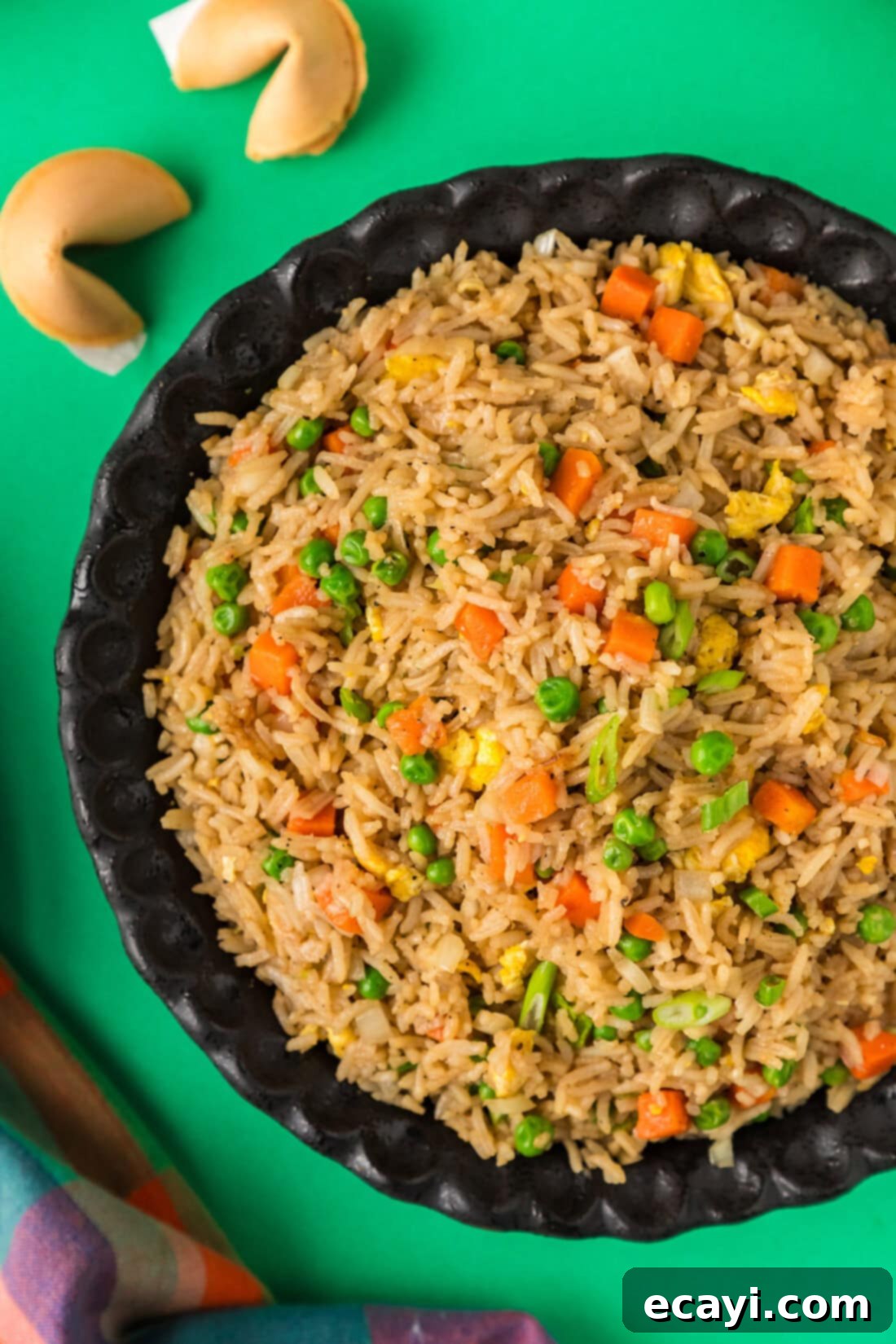 Golden Fried Rice Delights 2 Half a bowl of homemade Fried Rice with fortune cookies to the side, garnished with green onions