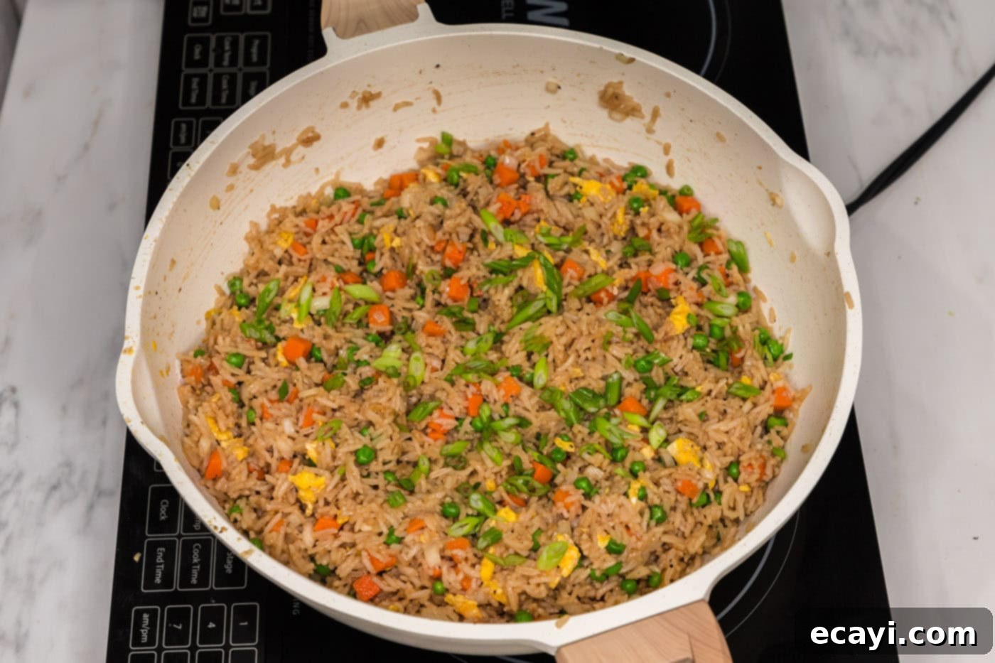 Golden Fried Rice Delights 13 Sliced green onions on top of vegetable fried rice in a skillet, ready to serve
