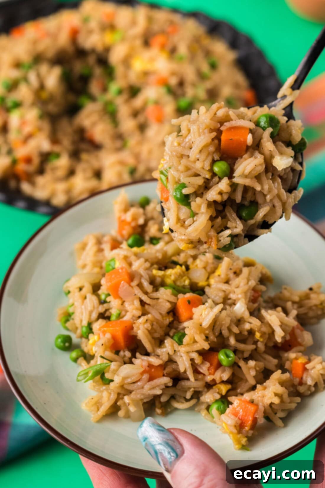 Golden Fried Rice Delights 3 Spoonful of Vegetable Fried Rice being served onto a plate, showcasing its vibrant colors