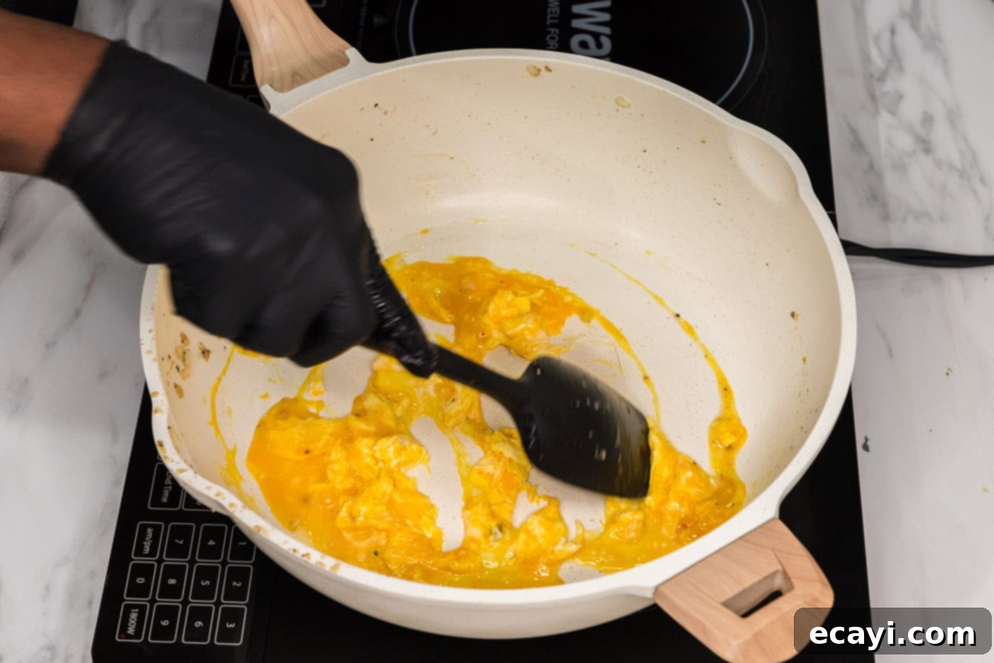 Golden Fried Rice Delights 7 Scrambling eggs in a skillet with a rubber spatula for fried rice