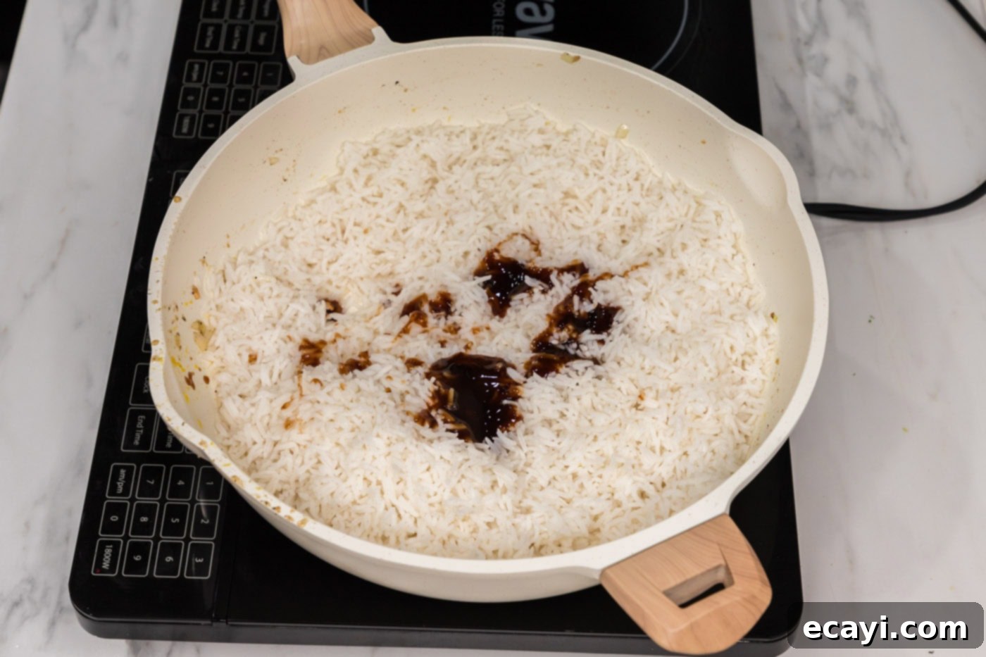 Golden Fried Rice Delights 9 Soy sauce and oyster sauce added to a skillet with rice, ready to be mixed