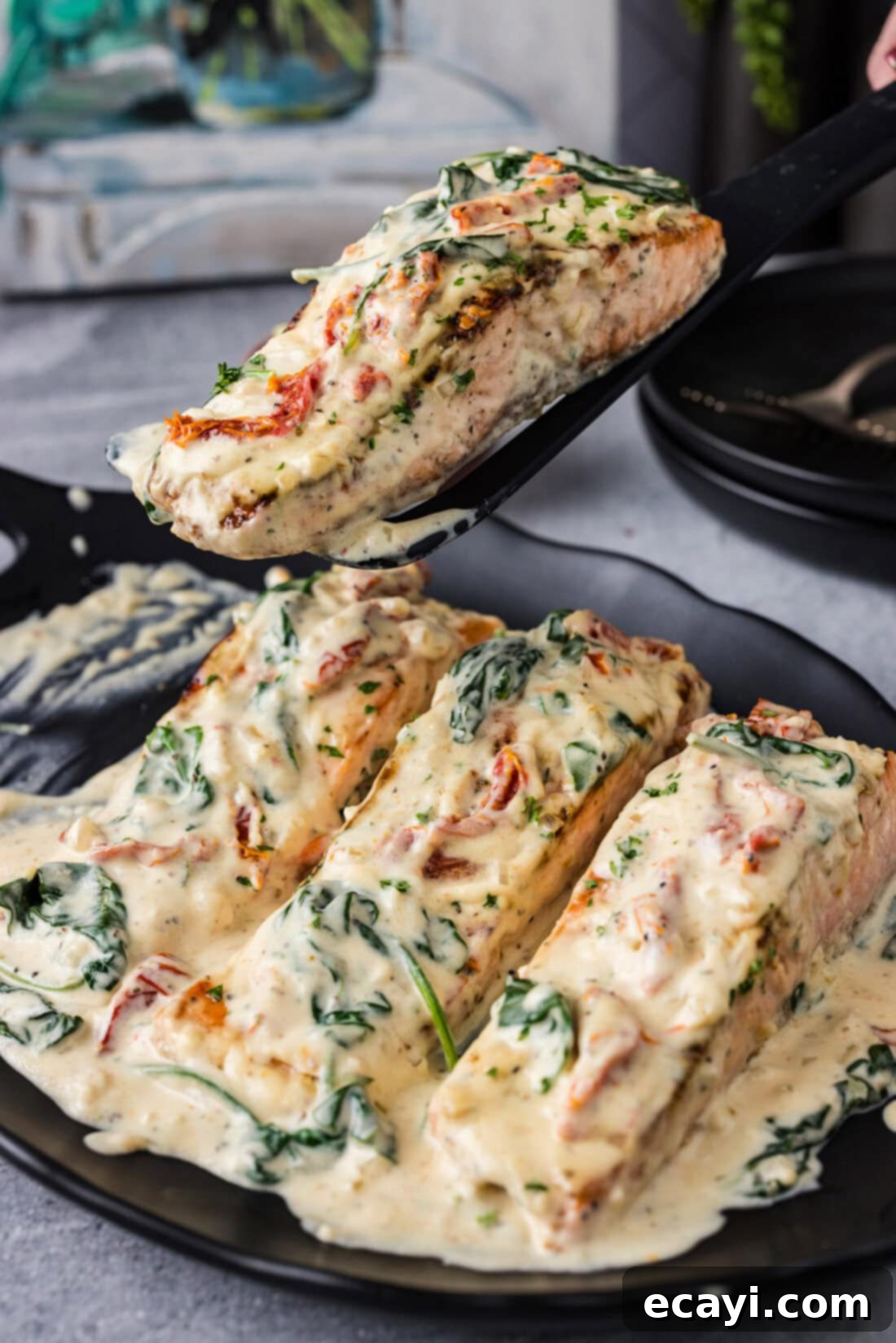 Creamy Tuscan Salmon 2 Spatula lifting up a Tuscan Salmon filet