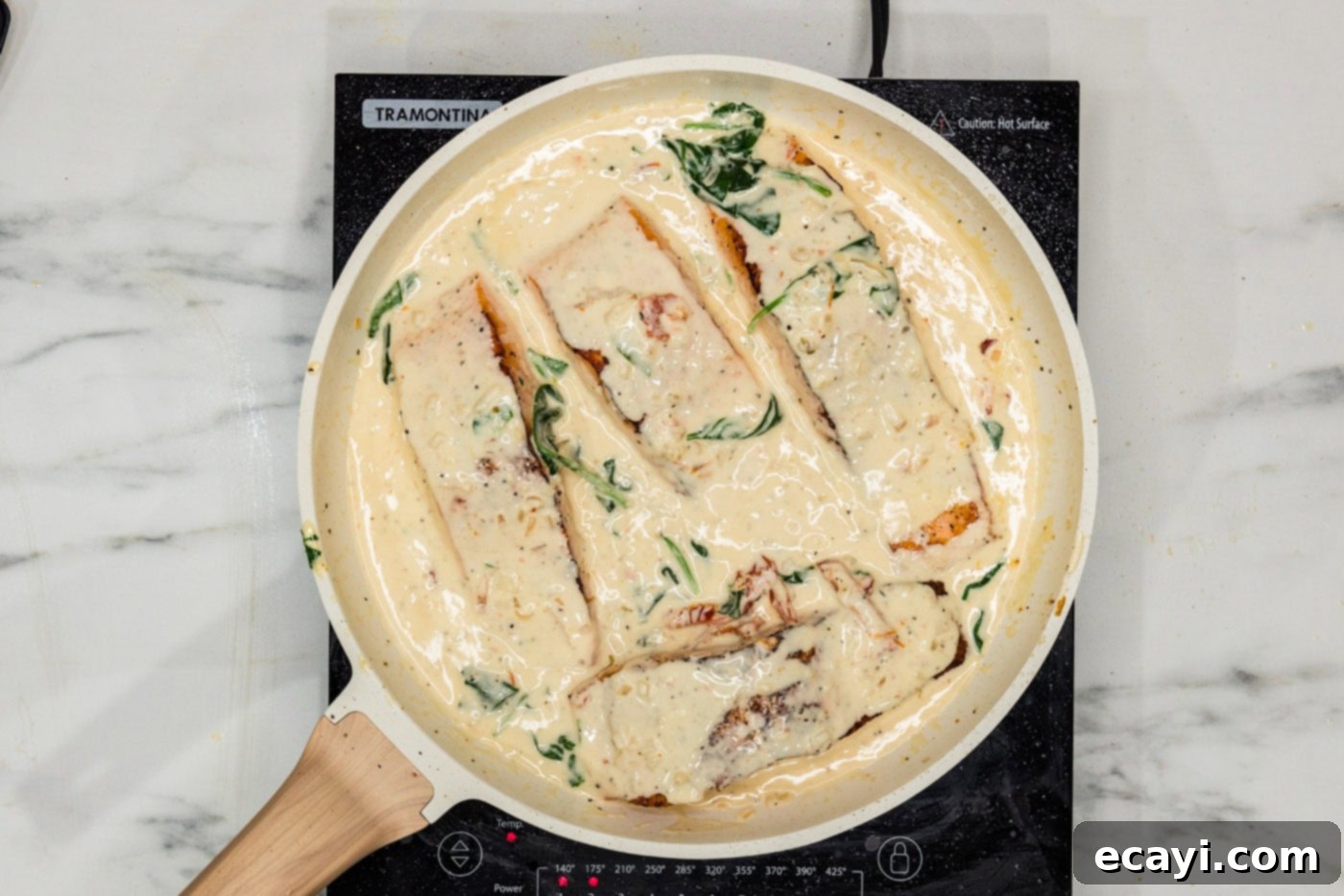 Creamy Tuscan Salmon 11 salmon filets in a skillet with cream sauce