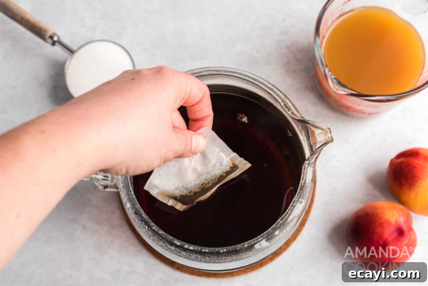 Sun-Kissed Peach Brew 5 Adding cold brew tea bags to a pitcher of water.