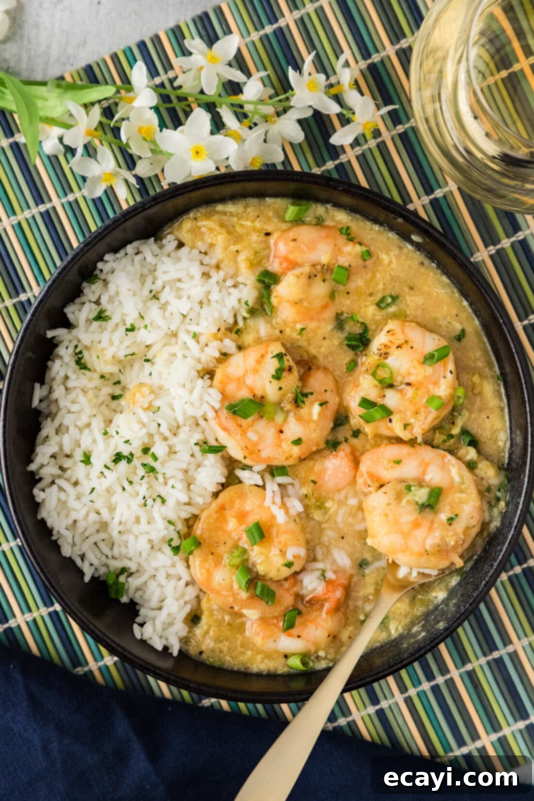 Velvety Lobster Sauce Shrimp 2 Shrimp with Lobster Sauce served in a bowl with rice and a spoon, garnished with green onions