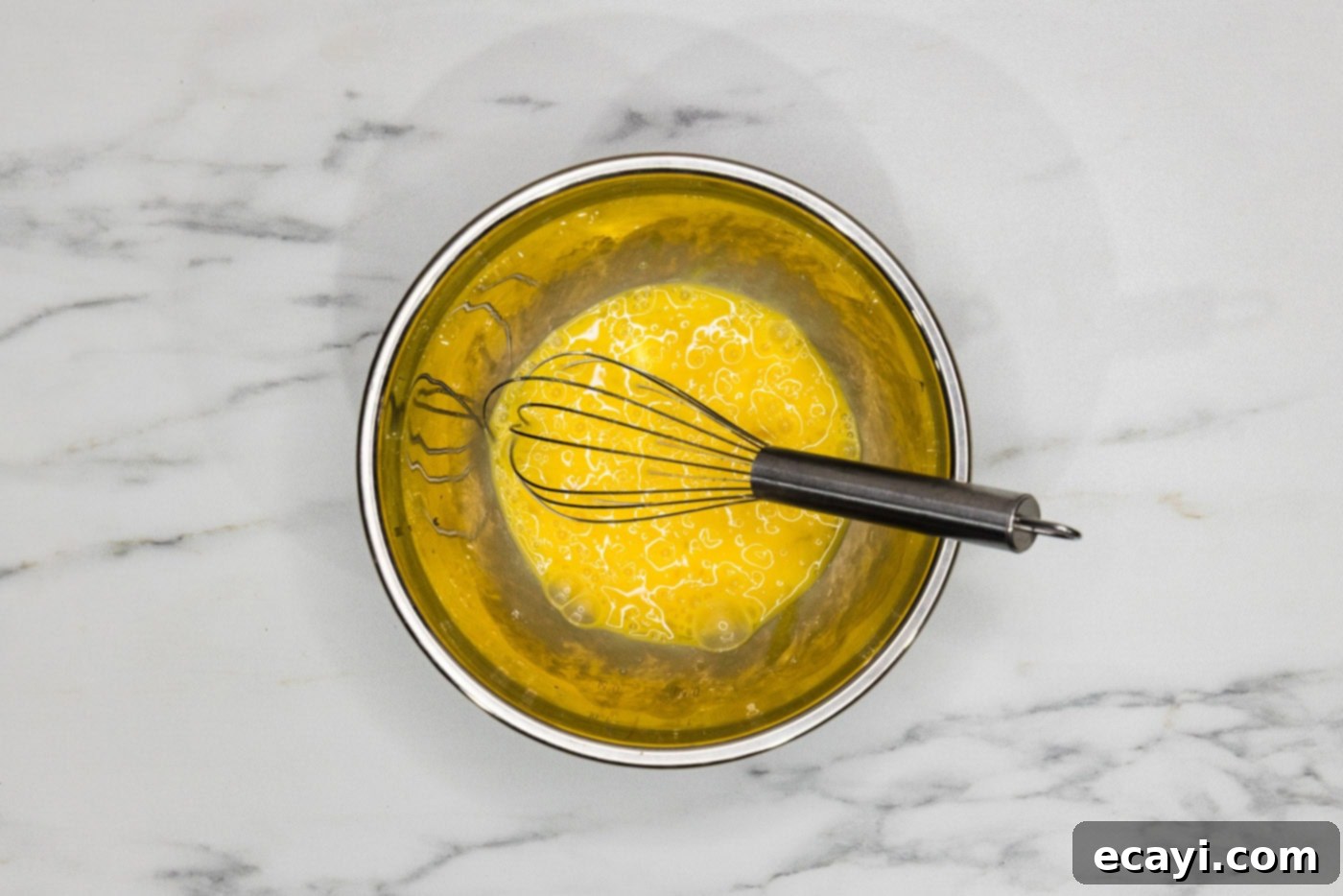 Velvety Lobster Sauce Shrimp 6 A bowl of whisked egg mixture with a whisk, ready for use in the recipe