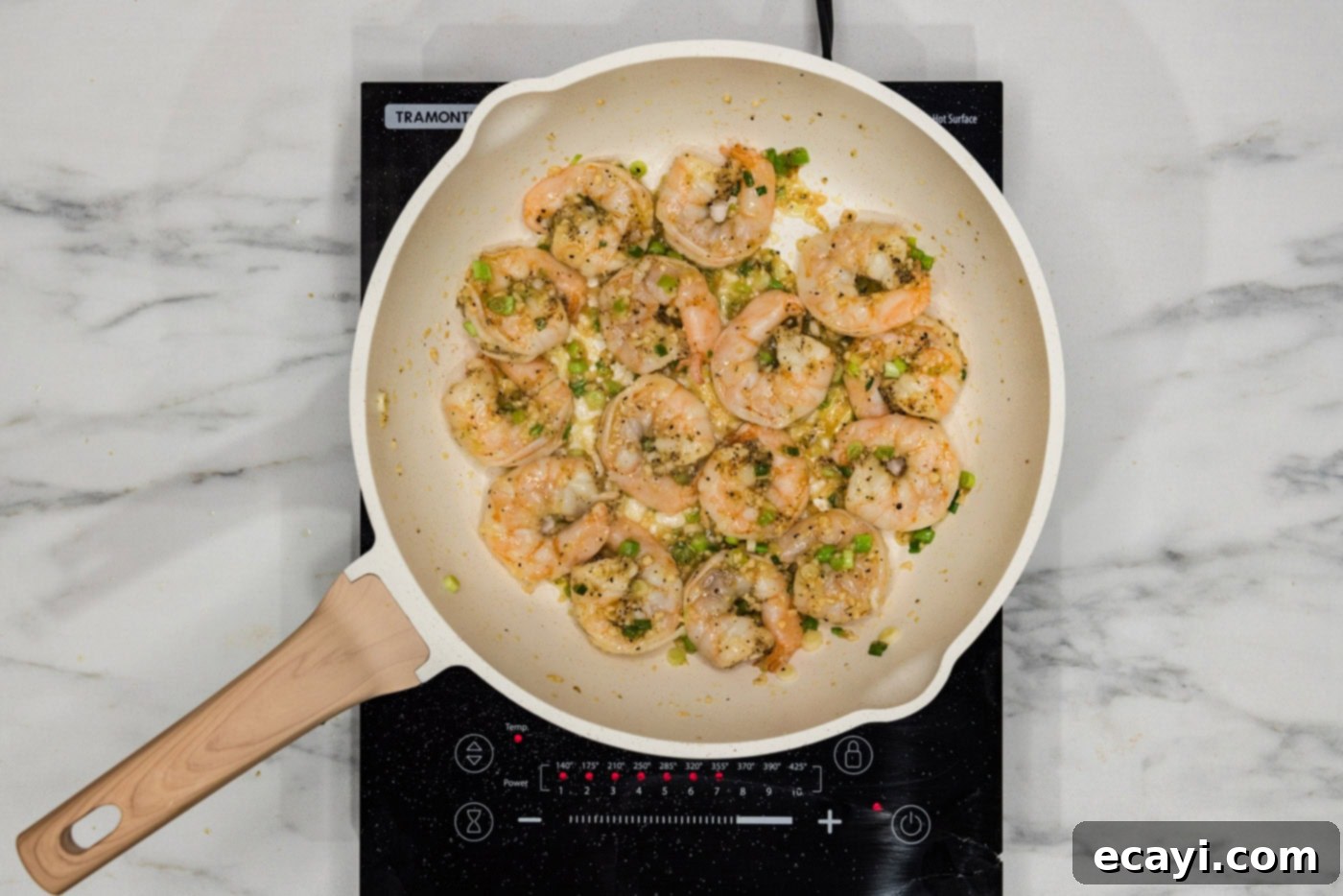 Velvety Lobster Sauce Shrimp 7 Pink cooked shrimp in a skillet with green onions, perfectly sautéed