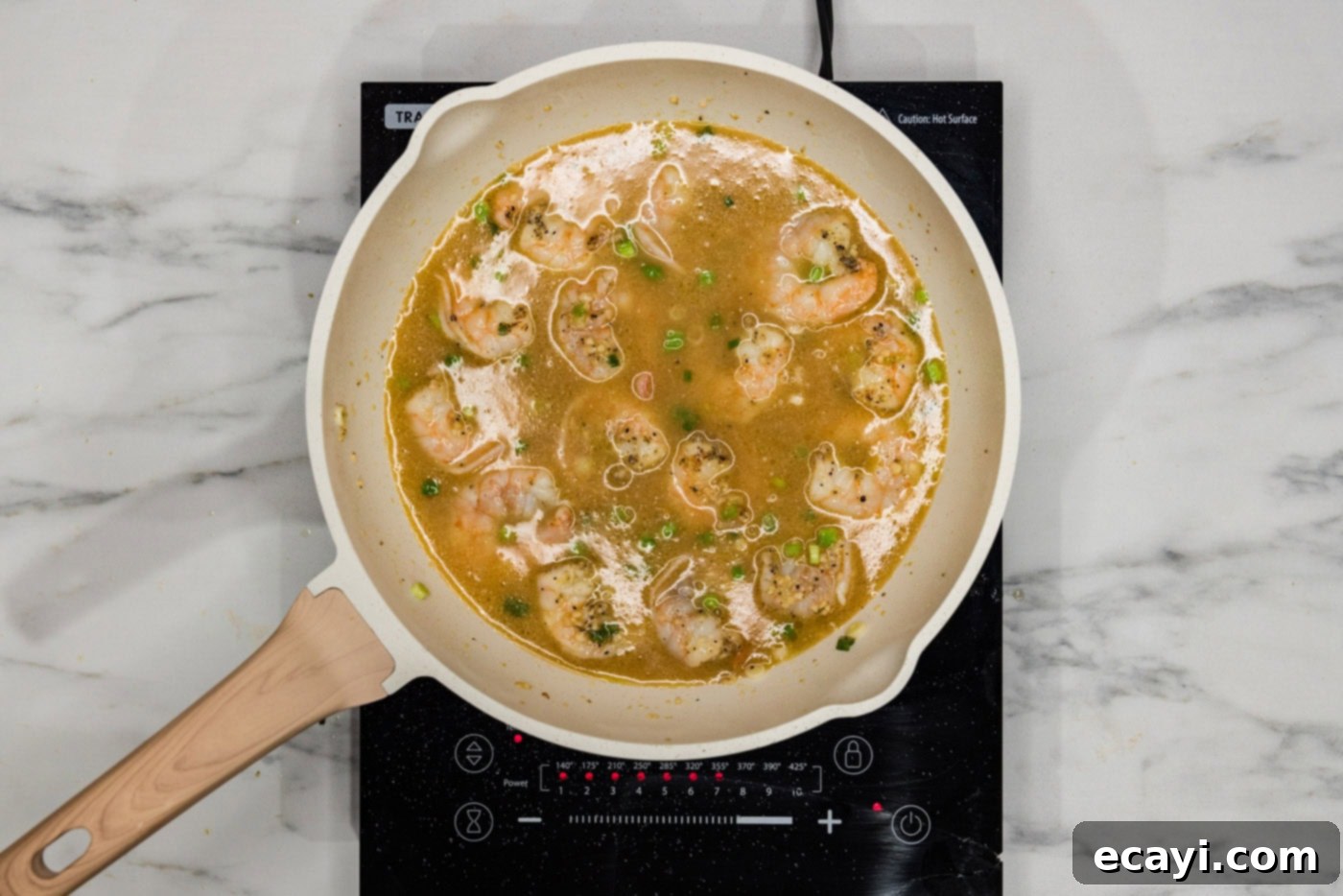 Velvety Lobster Sauce Shrimp 8 Chicken base mixture being added to the cooked shrimp in a skillet, creating the sauce