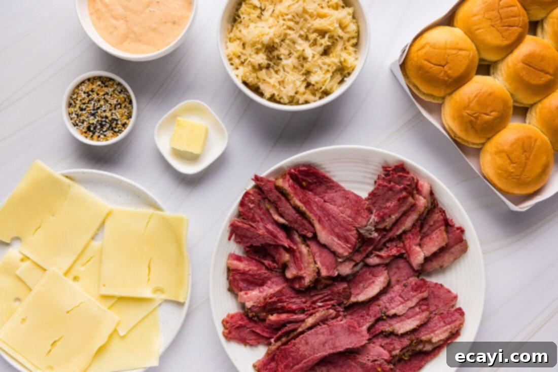 Reuben Bites 4 All the fresh ingredients laid out for making Reuben sliders, including corned beef, cheese, sauerkraut, buns, and dressing.