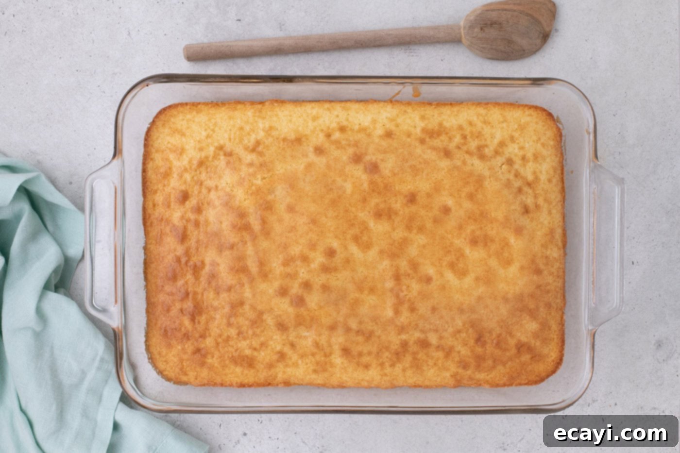 Tropical Coconut Infusion Cake 6 Freshly baked cake in a 9x13 inch baking dish, golden brown on top.