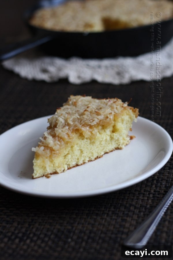 Effortless Golden Coconut Cake 2 A slice of lazy daisy cake on a white plate, showcasing its golden caramelized topping.