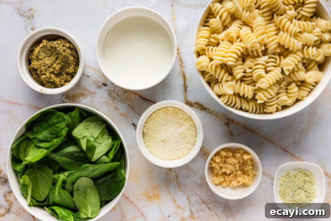 Pesto Perfection 4 A selection of ingredients laid out for making Pesto Pasta, including pasta, pesto, spinach, garlic, and cheese