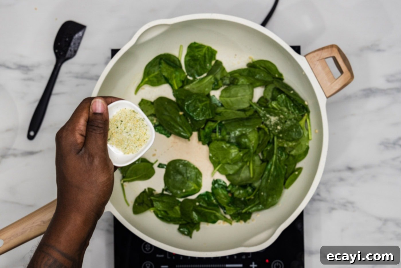 Pesto Perfection 5 seasoning spinach in a skillet with garlic salt