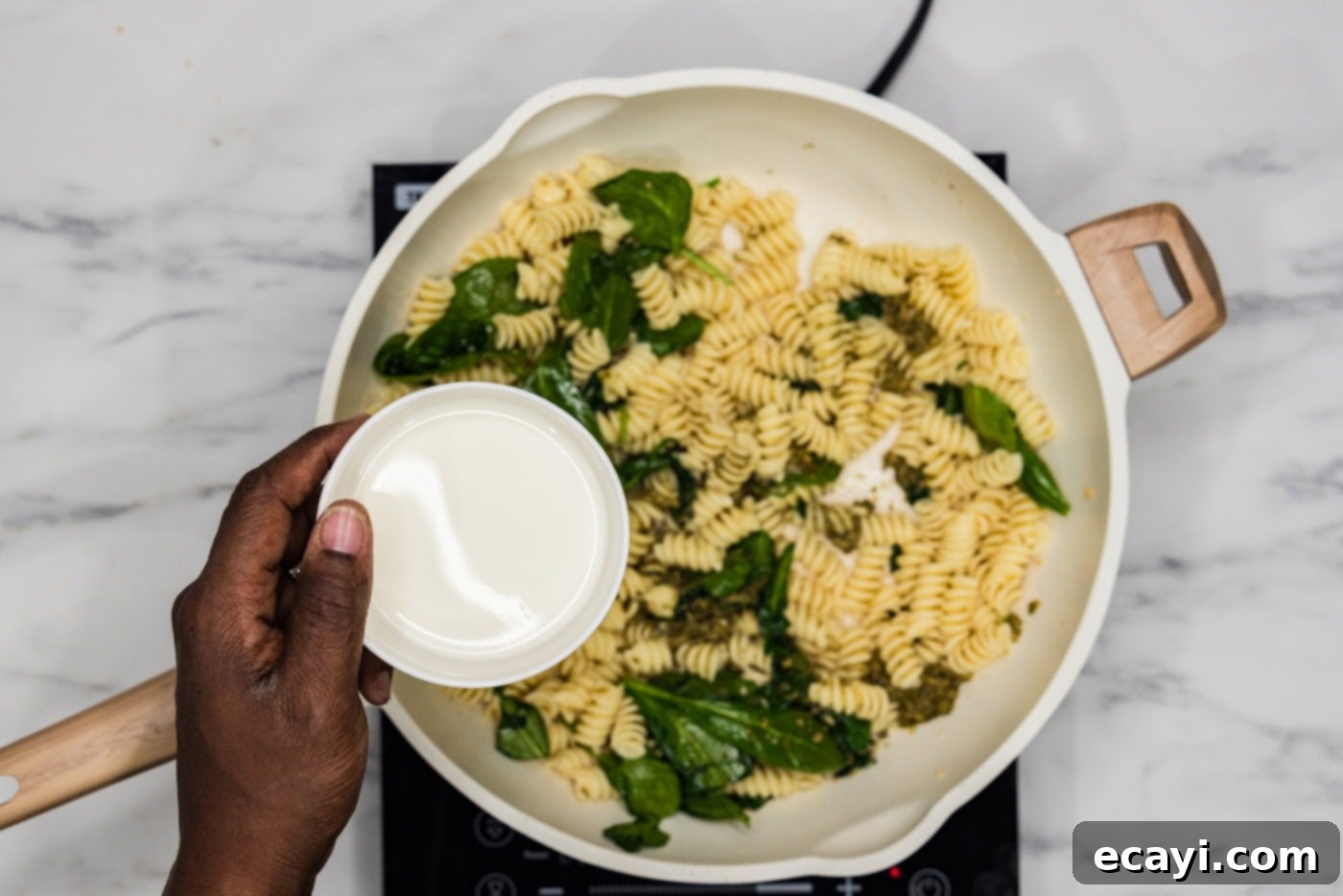 Pesto Perfection 7 adding heavy cream to skillet with spinach and pasta