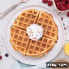 Cake Mix Waffle Wonders 9 A beautifully styled image of Cake Mix Waffles with berries and syrup.