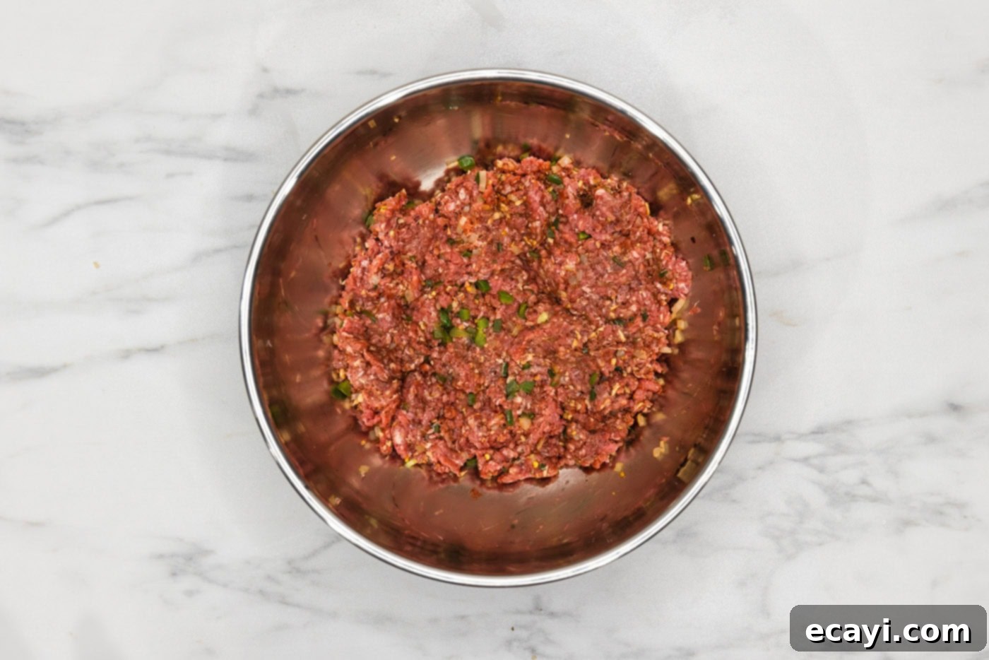 Taco Burger Fusion 6 Ground beef, taco seasoning, and sautéed vegetables combined in a mixing bowl, ready for forming.