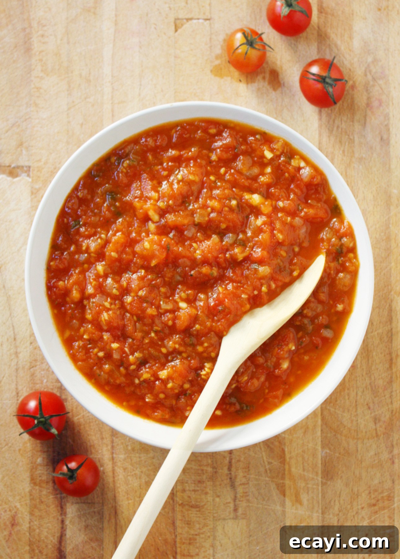 Crafting Perfect Fresh Tomato Sauce 2 A vibrant bowl of homemade fresh tomato sauce, garnished with fresh basil leaves, ready to be served. This image showcases the rich texture and inviting color of the summer tomato sauce.