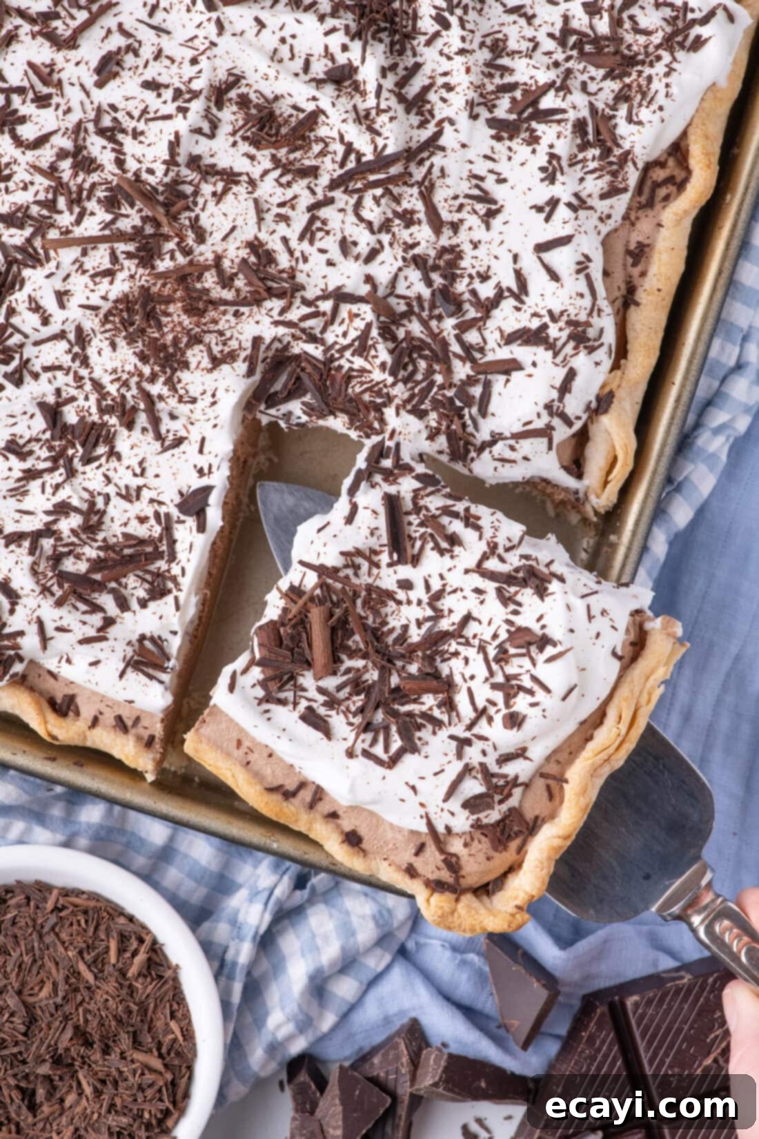 Ultimate French Silk Sheet Pie 3 Slice being removed from a French Silk Slab Pie, highlighting the smooth chocolate filling