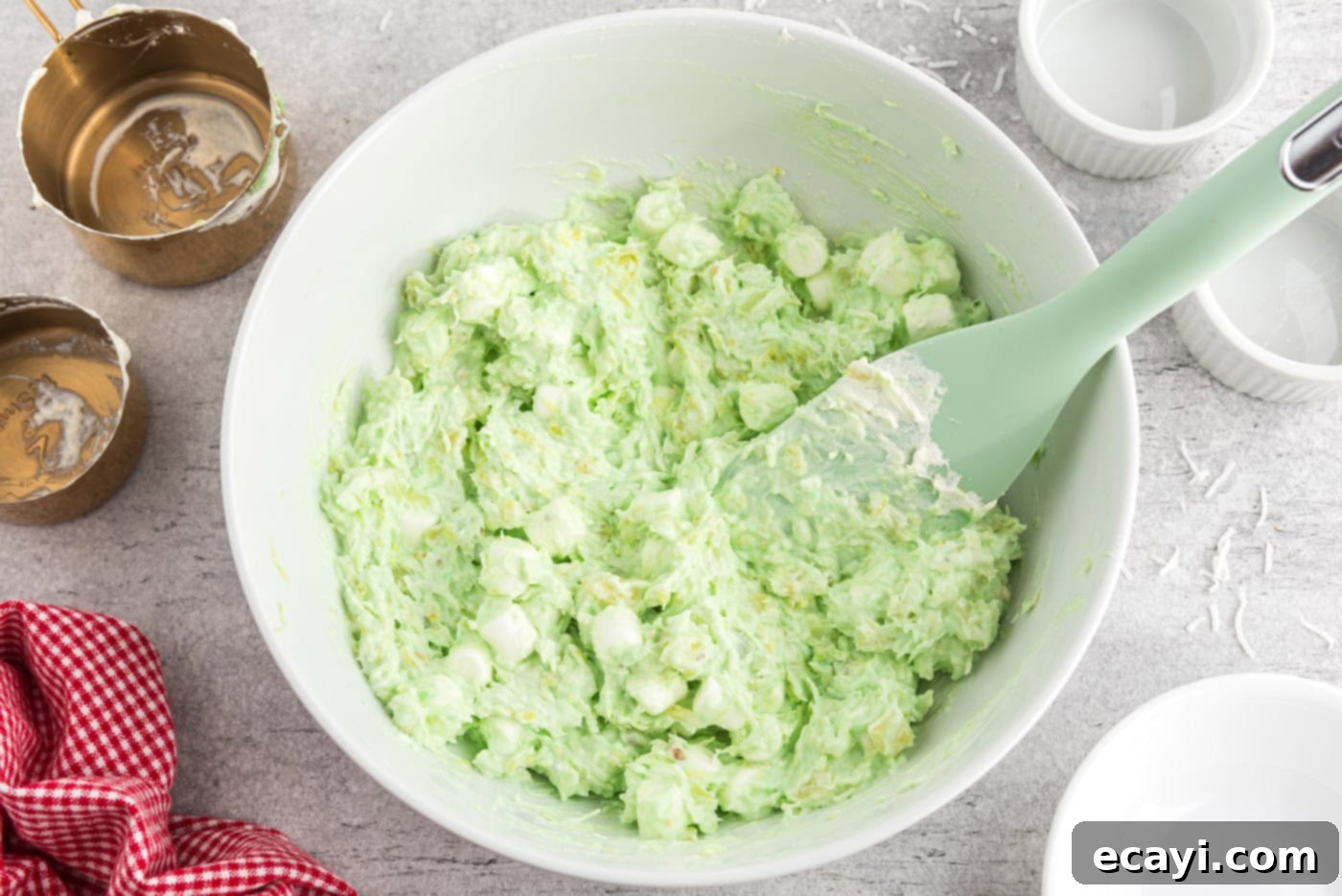 Pistachio Pineapple Delight 8 watergate salad in a bowl with a rubber spatula