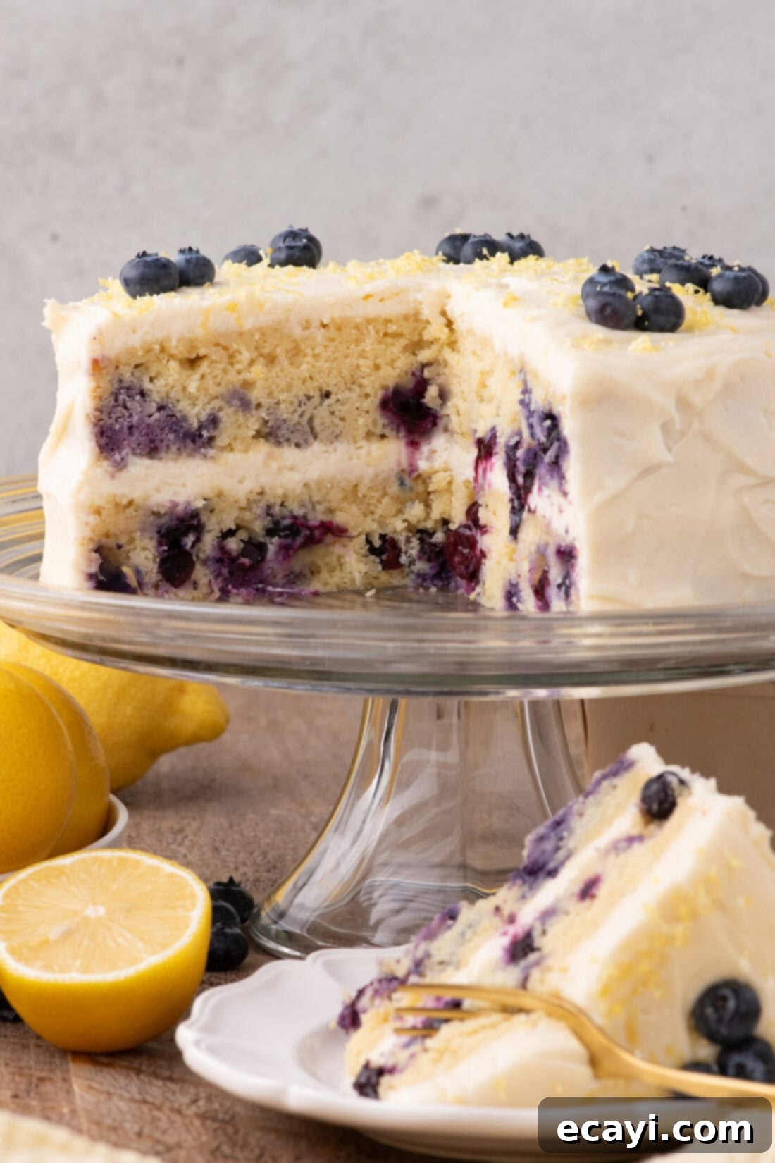 Zesty Lemon Blueberry Bliss 2 Lemon Blueberry Cake with slices removed, showcasing its layers and fresh fruit garnish