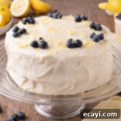 Zesty Lemon Blueberry Bliss 16 Lemon Blueberry Cake on a cake stand, beautifully frosted and garnished