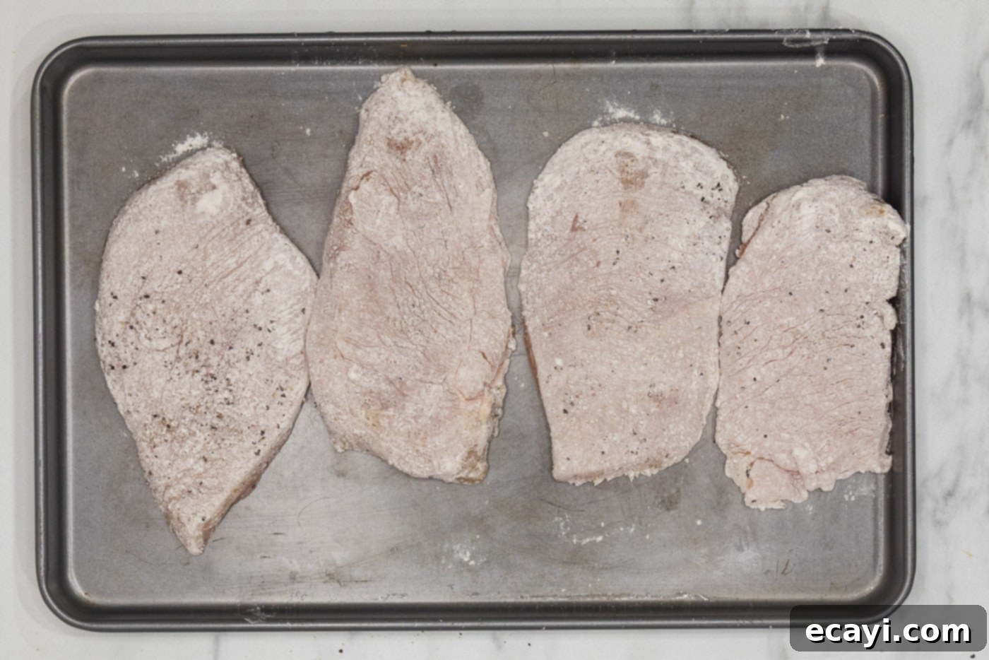 Tropical Coconut Chicken 5 flour dredged chicken on a baking sheet