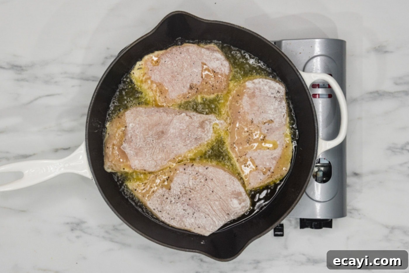 Tropical Coconut Chicken 6 dredged chicken cooking in hot oil