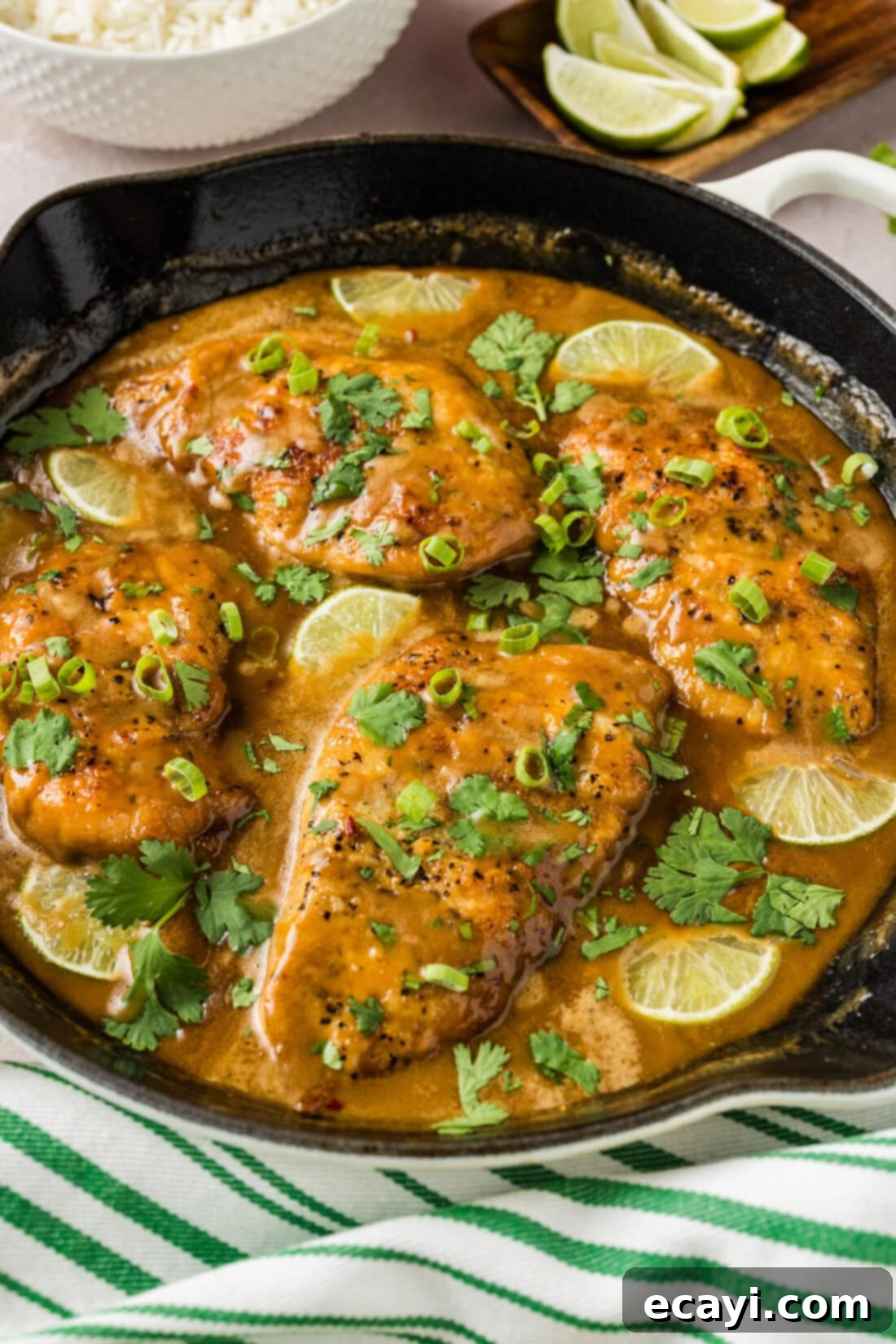 Tropical Coconut Chicken 10 Coconut Chicken in a skillet with rice and limes in the background