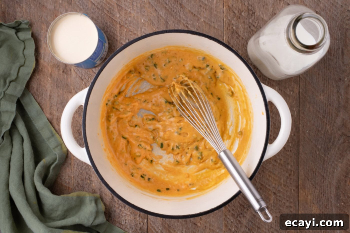 Spicy Cheesy Popper Mac 6 whisking evaporated milk into jalapeno mixture in a pot